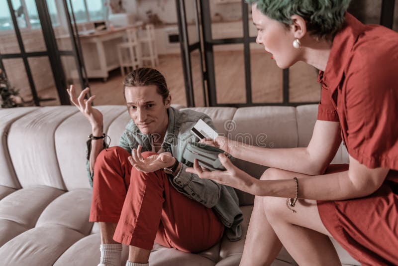 Gasto del marido demasiado dinero del presupuesto familiar imagen de archivo Gasto del marido demasiado dinero del presupuesto familiar imagen de archivo