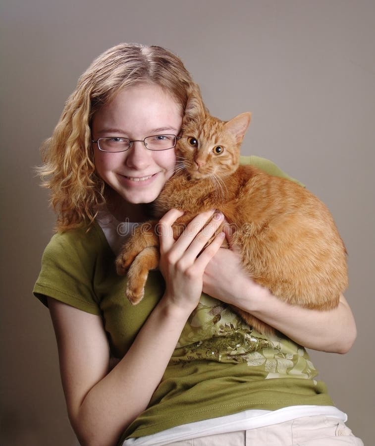 Portrait of a girl holding an orange cat. Portrait of a girl holding an orange cat.