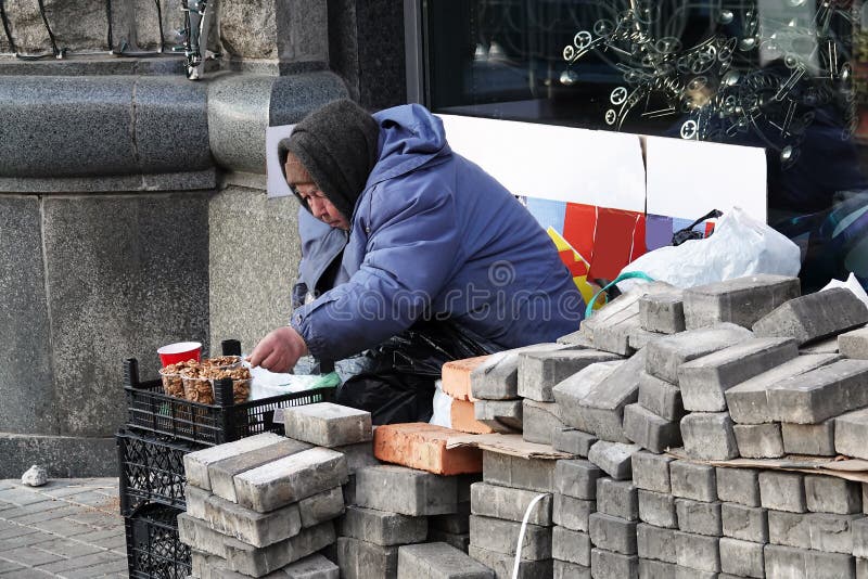 Kiev, Ukraine December 9, 2019: Sale of goods on a street of the city of Kiev, an old grandmother sells walnuts. Kiev, Ukraine December 9, 2019: Sale of goods on a street of the city of Kiev, an old grandmother sells walnuts