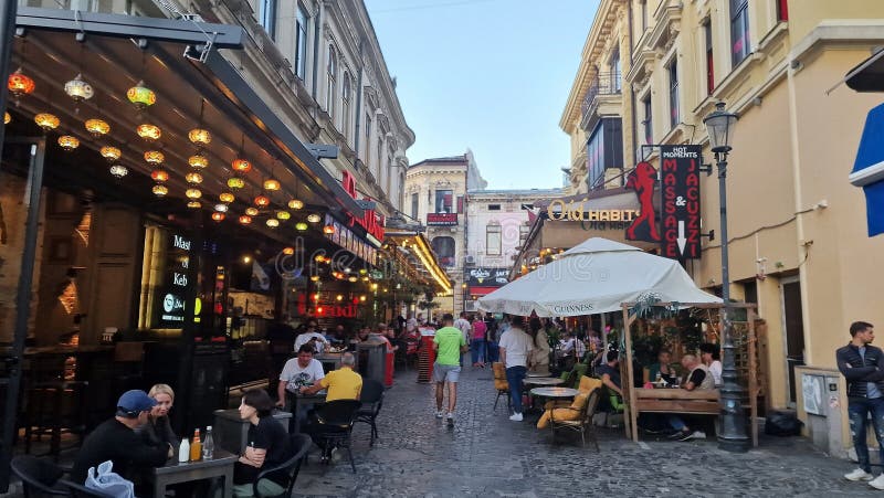 October, 14, 2023. Tourists and locals enjoy the nightlife in the old town of Bucharest, Romania. Street view, with old buildings, people, street cafes and restaurants. October, 14, 2023. Tourists and locals enjoy the nightlife in the old town of Bucharest, Romania. Street view, with old buildings, people, street cafes and restaurants.