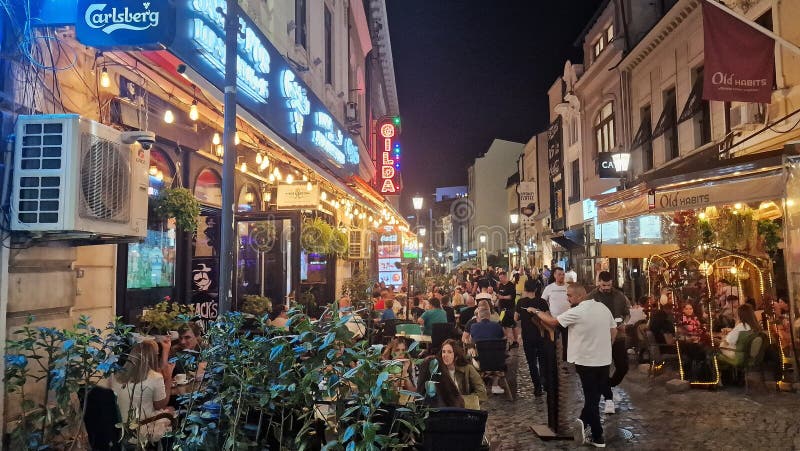 October, 14, 2023. Tourists and locals enjoy the nightlife in the old town of Bucharest, Romania. Street view, with old buildings, people, street cafes and restaurants. October, 14, 2023. Tourists and locals enjoy the nightlife in the old town of Bucharest, Romania. Street view, with old buildings, people, street cafes and restaurants.