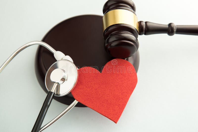 Gavel avec le coeur et le stéthoscope rouges sur le blanc médical photographie stock Gavel avec le coeur et le stéthoscope rouges sur le blanc médical photographie stock