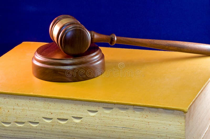 Una vista in legno, con martelletto e suono di blocco poggiano su un grande indicizzato il libro della legge sul velluto blu di sfondo.