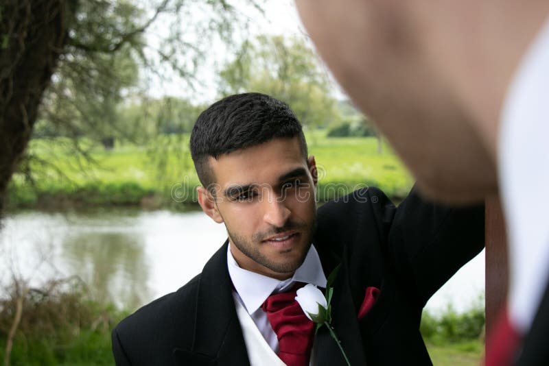 Gay couple of grooms pose for photographs by a lake on their wedding day stock photography Gay couple of grooms pose for photographs by a lake on their wedding day stock photography