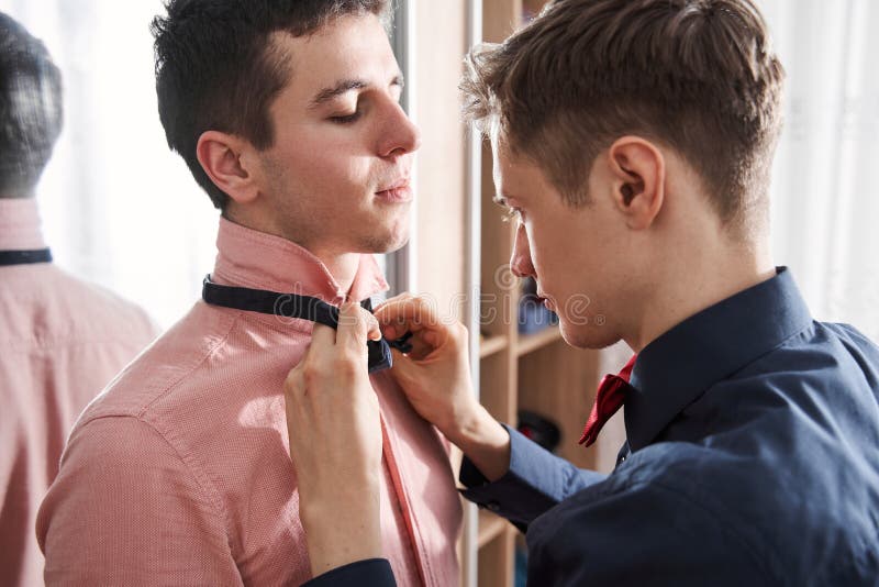 gay man helping to put bow tie to his boyfriend near mirror look great portrait view stylish gay men helping to put 215881307