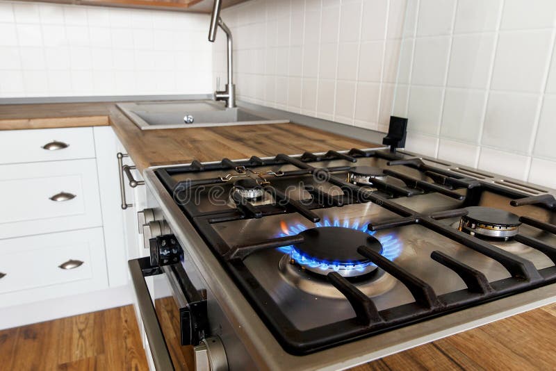 Gaz brûlant de fourneau de cuisine sur le fond de la cuisine élégante photo stock Gaz brûlant de fourneau de cuisine sur le fond de la cuisine élégante photo stock