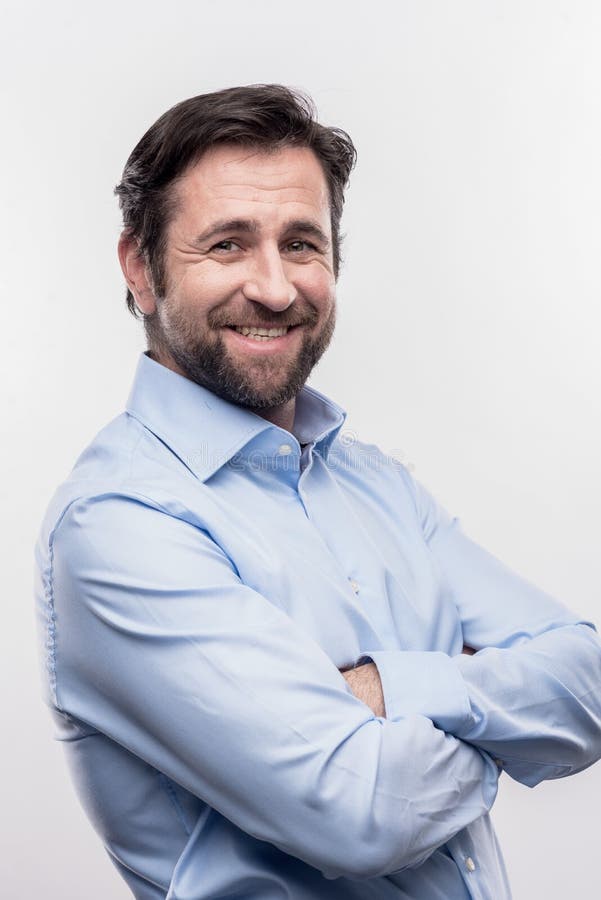 Gebaarde donker-haired bureaumanager die zich op voorzijde van witte muur bevinden royalty-vrije stock fotografie Gebaarde donker-haired bureaumanager die zich op voorzijde van witte muur bevinden royalty-vrije stock fotografie