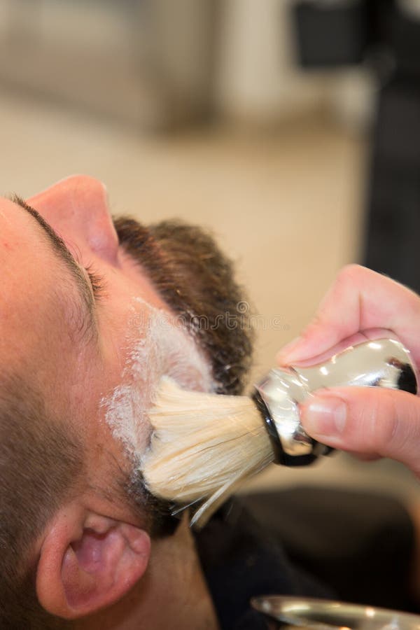 Gebaarde mens die baardkapsel krijgen bij kapper bij herenkapper stock afbeelding Gebaarde mens die baardkapsel krijgen bij kapper bij herenkapper stock afbeelding