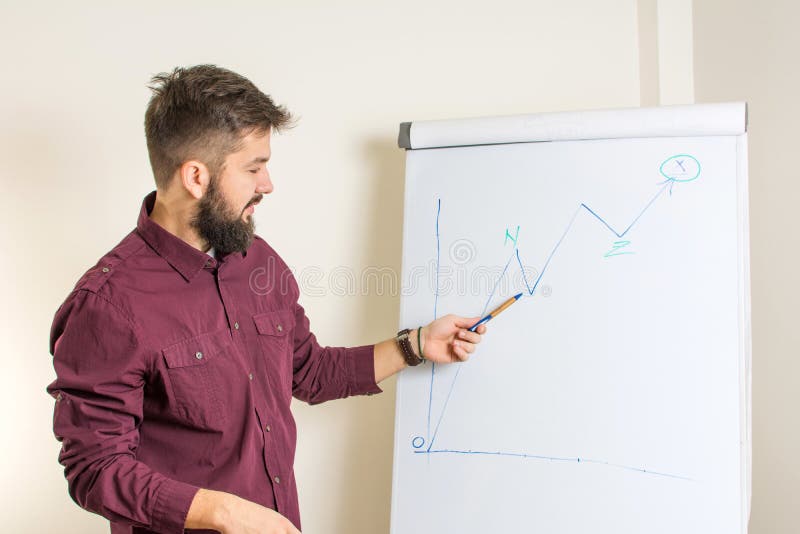 Gebaarde mens die door flipchart voorstellen stock foto Gebaarde mens die door flipchart voorstellen stock foto