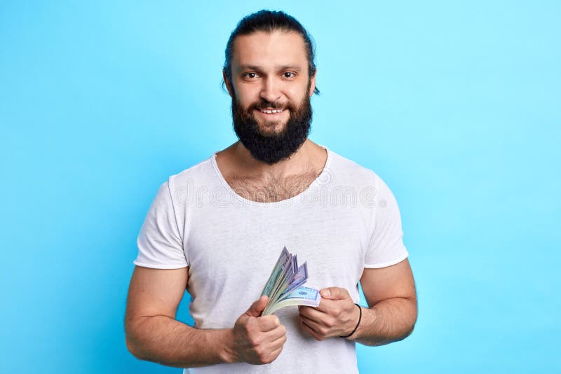 Gebaarde zakenman die met geld de camera bekijken stock foto Gebaarde zakenman die met geld de camera bekijken stock foto