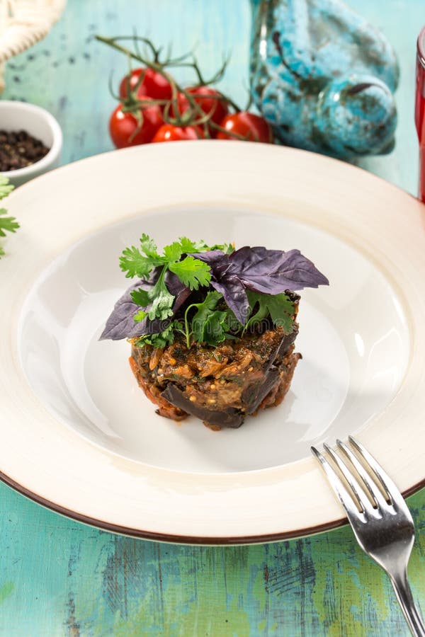 Gebakken aubergine met basilicum op bovenkant op blauwe houten lijst stock afbeelding Gebakken aubergine met basilicum op bovenkant op blauwe houten lijst stock afbeelding