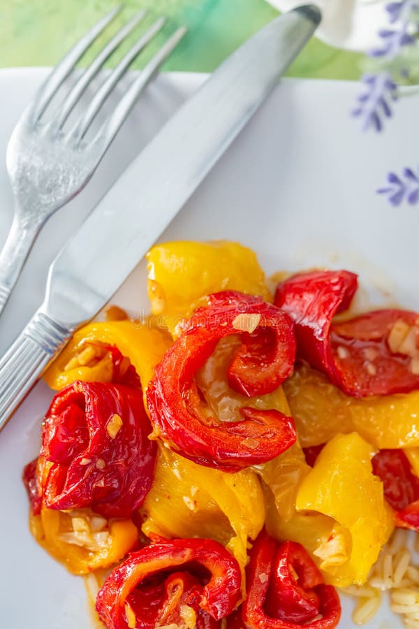 Gebakken gele Spaanse peper op een witte plaat en een vork en mes Vegetarisch voedsel Zachte nadruk Hoogste mening stock afbeeldingen Gebakken gele Spaanse peper op een witte plaat en een vork en mes Vegetarisch voedsel Zachte nadruk Hoogste mening stock afbeeldingen
