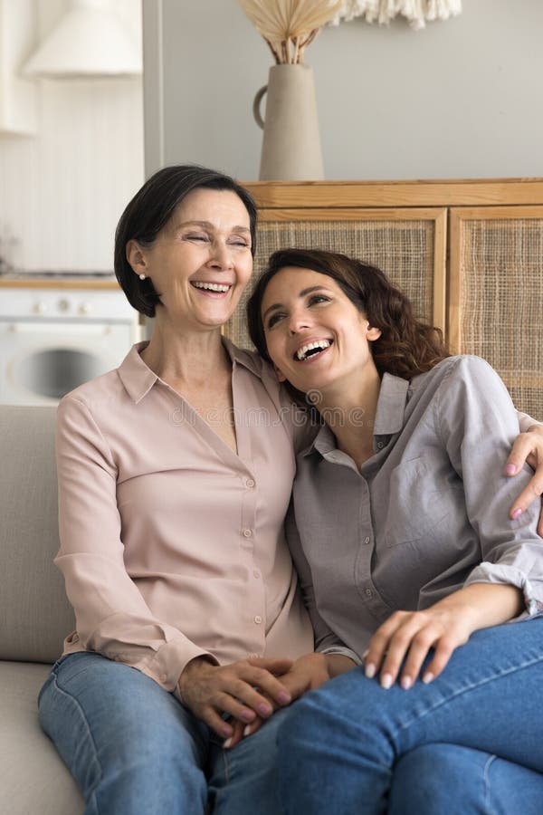 Gebetete alleinerziehende Kuschelkresse geliebte erwachsene Tochter auf Couch lizenzfreies stockfoto