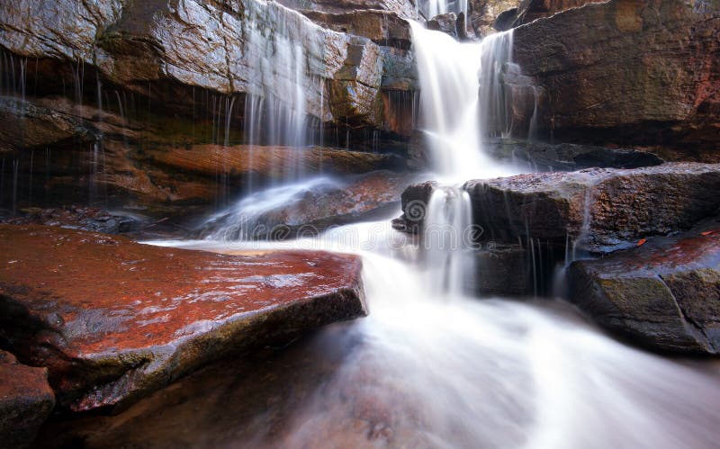 Gebirgsflusswasserfall, -felsen und -Trinkwasser stockfotos