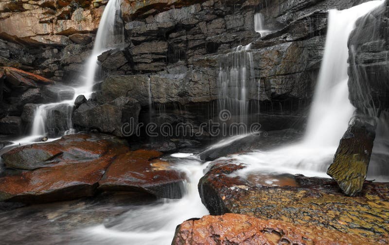 Gebirgsflusswasserfall, -felsen und -Trinkwasser stockbilder