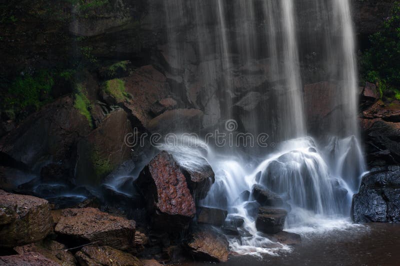Gebirgsflusswasserfall, -felsen und -Trinkwasser stockbild