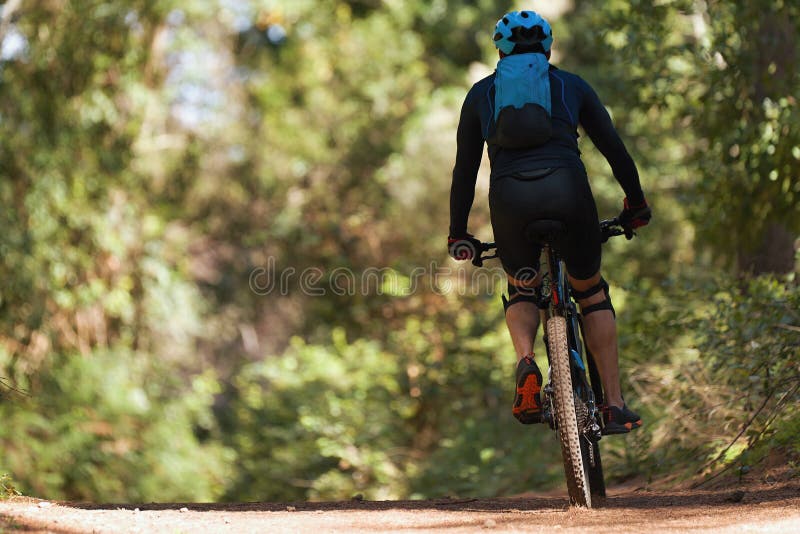 Mountain biking man riding on bike in summer mountains forest landscape. Mountain biking man riding on bike in summer mountains forest landscape