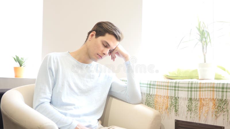 Gebohrter, müder Mann, der am Sofa an seinem Arbeitsplatz schläft lizenzfreie stockfotos Gebohrter, müder Mann, der am Sofa an seinem Arbeitsplatz schläft lizenzfreie stockfotos