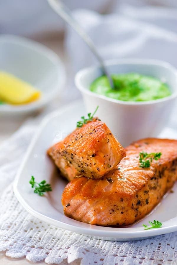 Gebraden filet van een zalm met groene erwtensaus royalty-vrije stock afbeeldingen Gebraden filet van een zalm met groene erwtensaus royalty-vrije stock afbeeldingen