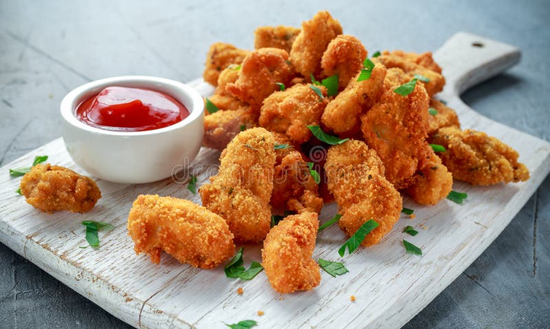 Gebraden knapperige kippengoudklompjes met ketchup op witte raad royalty-vrije stock foto Gebraden knapperige kippengoudklompjes met ketchup op witte raad royalty-vrije stock foto