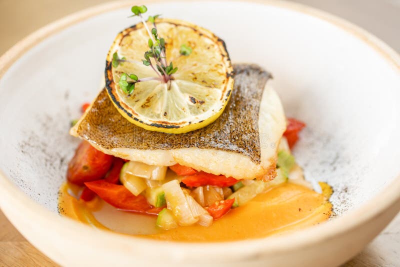 Gebrande snoepbaars of kabeljauw met gebakken groenten Schudden met een stuk citroen menu Restaurant royalty-vrije stock afbeeldingen Gebrande snoepbaars of kabeljauw met gebakken groenten Schudden met een stuk citroen menu Restaurant royalty-vrije stock afbeeldingen