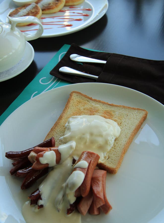 Sausages and sop in the pan served with white sauce. Sausages and sop in the pan served with white sauce