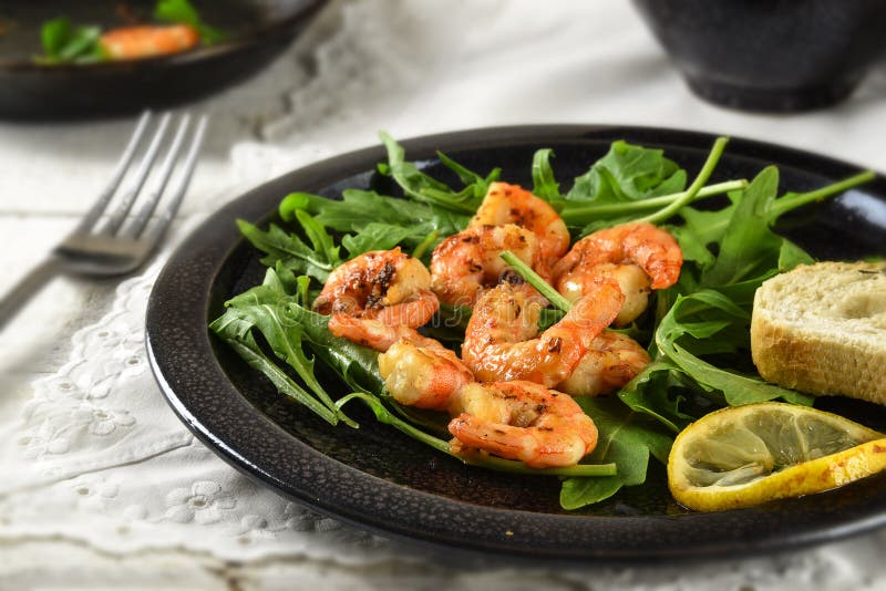 Gebratene Garnelen oder Garnelen auf rucola Raketensalat mit Zitrone und stockfotos