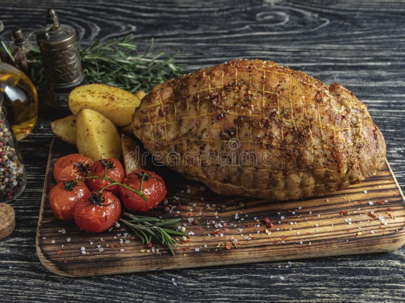 Gebratene GrillSchweinefleischroulade, Rolle mit Kartoffel und Tomate auf einem Schneidebrett lizenzfreies stockfoto