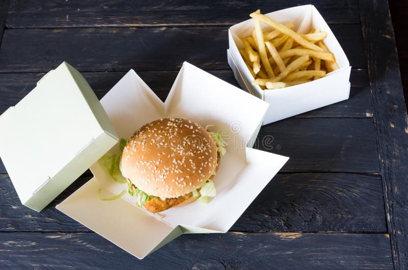 Gebratene Kartoffeln und Hamburger Schwarzer hölzerner Hintergrund stockbild Gebratene Kartoffeln und Hamburger Schwarzer hölzerner Hintergrund stockbild