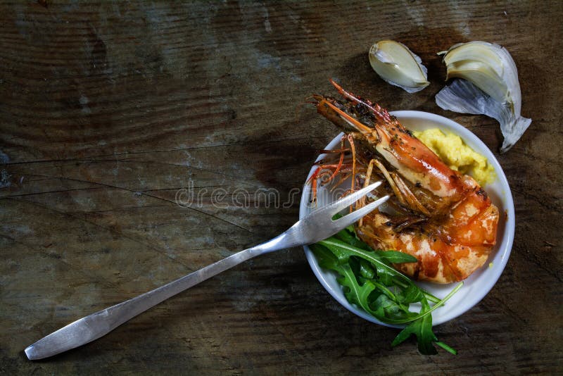 Gebratene schwarze Tigergarnele mit Raketensalat und Bad als mediterra stockfotografie Gebratene schwarze Tigergarnele mit Raketensalat und Bad als mediterra stockfotografie
