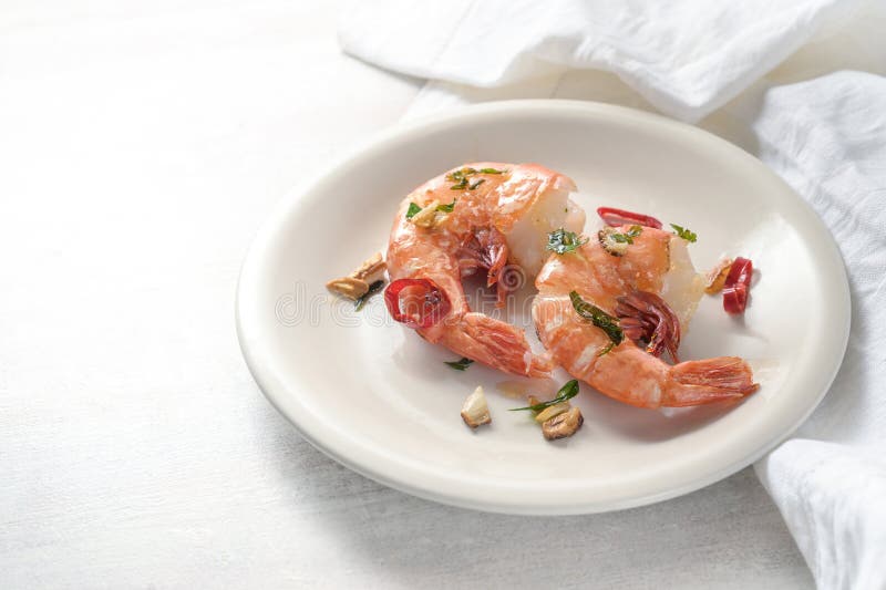 Gebratene Tigergarnelen oder Garnelen mit Knoblauchkräutern und rotem Chili Pfeffer, serviert auf einem weißen Teller scharfe Meer stockfotografie
