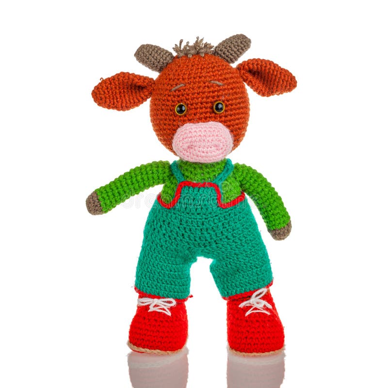 Knitted woven sewn wool toy in the form of an animal bull, isolated on a white background, a soft toy for children. Knitted woven sewn wool toy in the form of an animal bull, isolated on a white background, a soft toy for children