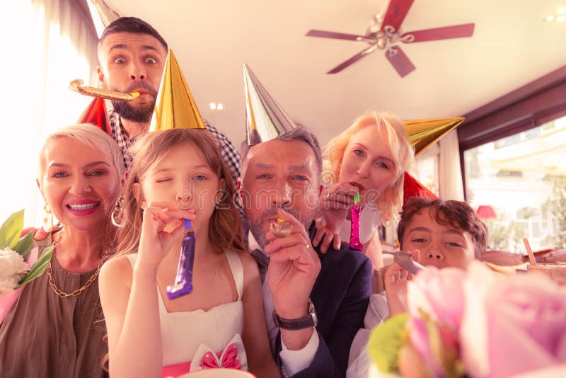 Geburtstagsmädchen, das wirklich glücklichem feierndem Geburtstag mit Familie glaubt lizenzfreie stockfotos Geburtstagsmädchen, das wirklich glücklichem feierndem Geburtstag mit Familie glaubt lizenzfreie stockfotos