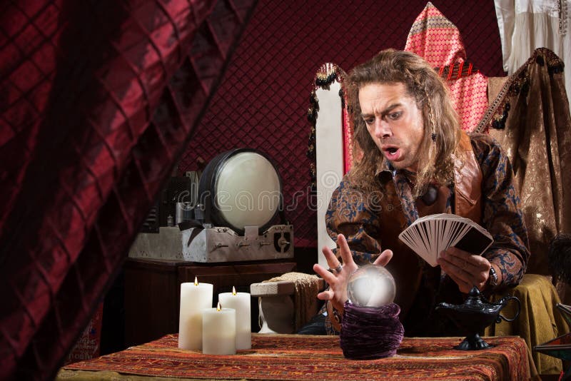 Male fortune teller concentrating on his crystal ball. Male fortune teller concentrating on his crystal ball