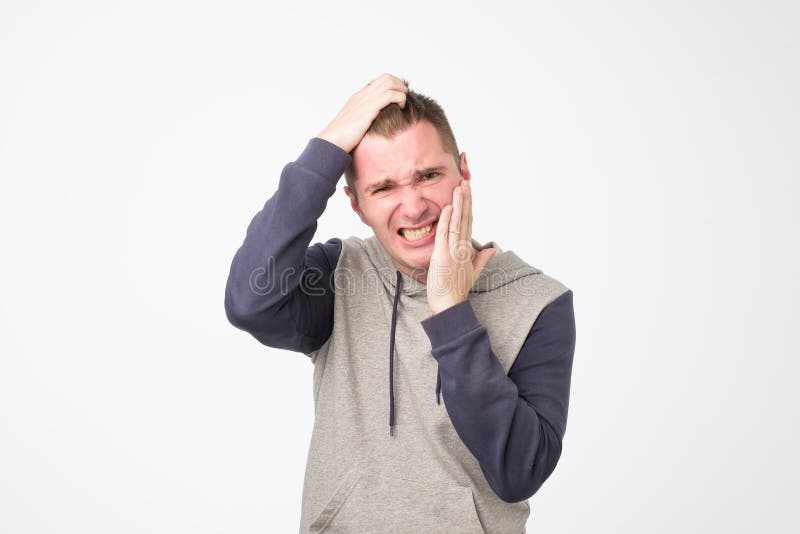 Gedeprimeerde zieke mens die tandpijn en wat betreft wang hebben royalty-vrije stock foto Gedeprimeerde zieke mens die tandpijn en wat betreft wang hebben royalty-vrije stock foto