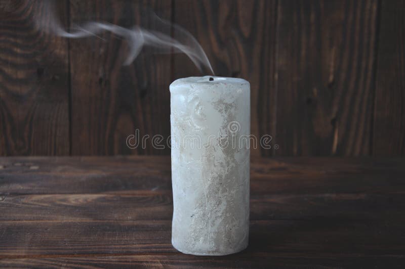 Gedoofde grote kaars in dark Op een houten achtergrond Kaarsrook stock foto Gedoofde grote kaars in dark Op een houten achtergrond Kaarsrook stock foto