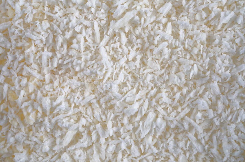 A close-up image of desiccated coconut. Coconut shredded and dried to remove as much moisture as possible. The image may be suitable as a background or texture. A close-up image of desiccated coconut. Coconut shredded and dried to remove as much moisture as possible. The image may be suitable as a background or texture.