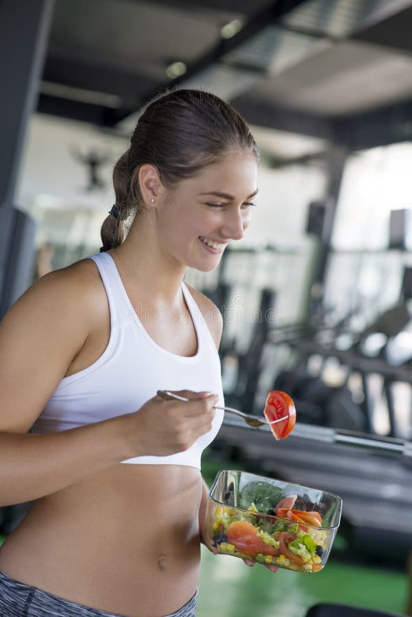 Geeignete Frau, die gesunden Salat nach Training isst lizenzfreie stockfotos Geeignete Frau, die gesunden Salat nach Training isst lizenzfreie stockfotos