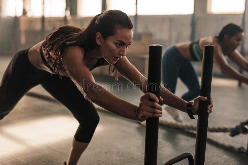 Geeignete Frauen, die an der Turnhalle trainieren lizenzfreies stockfoto Geeignete Frauen, die an der Turnhalle trainieren lizenzfreies stockfoto