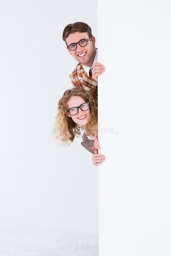 Geeky modnisia mienia plakat i ono uśmiecha się przy kamerą zdjęcia stock