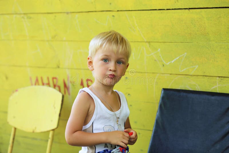 Geel de zomerhuis en een kleine jongen royalty-vrije stock afbeeldingen Geel de zomerhuis en een kleine jongen royalty-vrije stock afbeeldingen