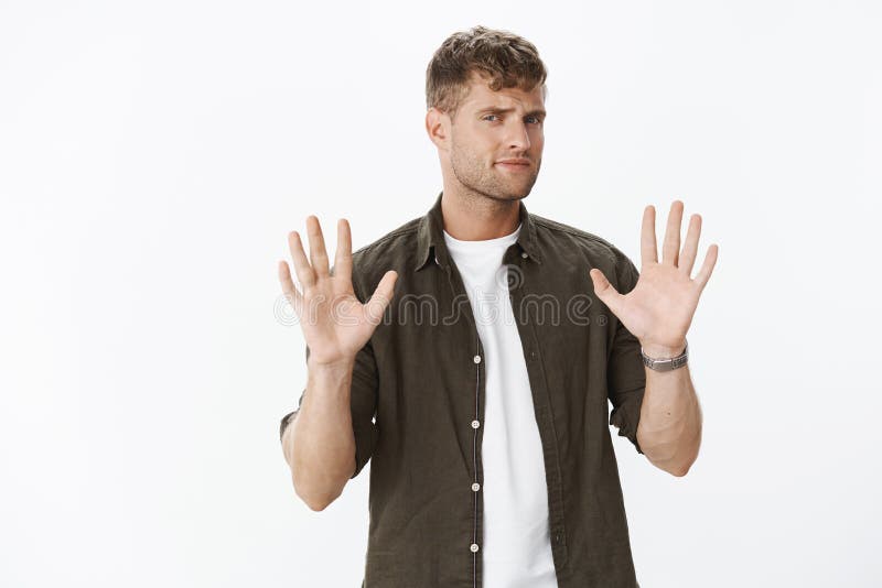 Geen dank Aarzelende niet onder de indruk zijnde en ontstemde knappe mannelijke klant die palmen in weigering opheffen, die frons stock afbeeldingen Geen dank Aarzelende niet onder de indruk zijnde en ontstemde knappe mannelijke klant die palmen in weigering opheffen, die frons stock afbeeldingen