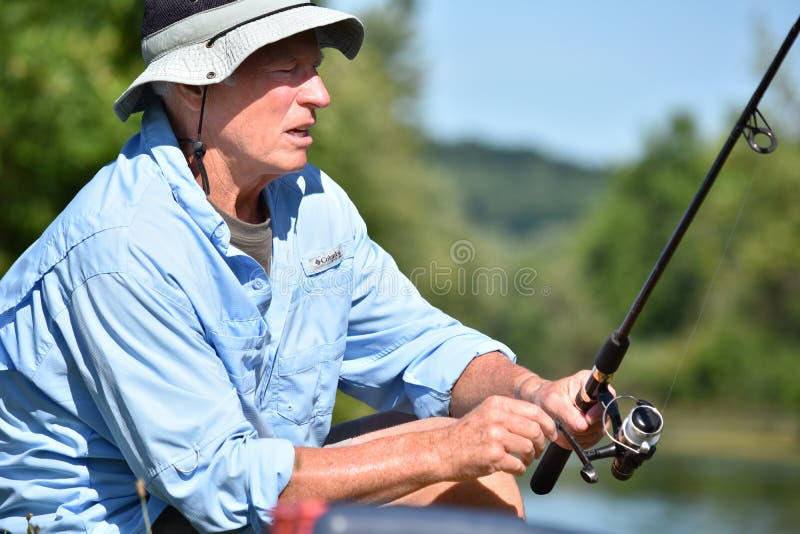 Gefühlloser männlicher Fischer Outdoorsman With Rod And Reel Fishing stockfotografie Gefühlloser männlicher Fischer Outdoorsman With Rod And Reel Fishing stockfotografie
