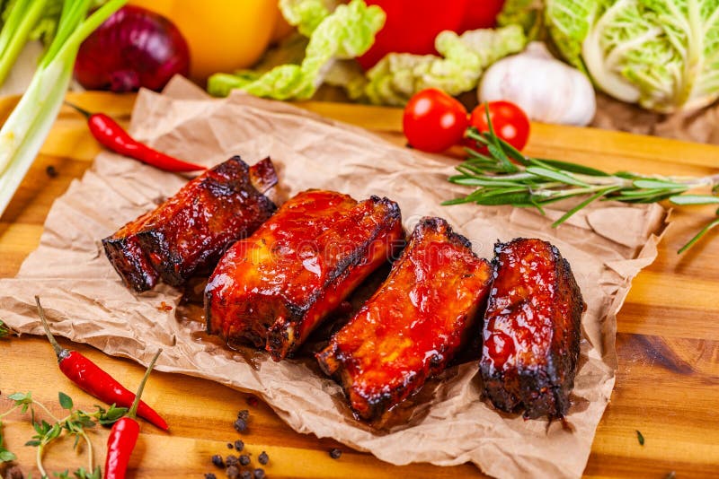 Gegrillte Grillschweinefleischrippen mit Gewürzen und Kräutern auf hölzernem Brett stockbild Gegrillte Grillschweinefleischrippen mit Gewürzen und Kräutern auf hölzernem Brett stockbild