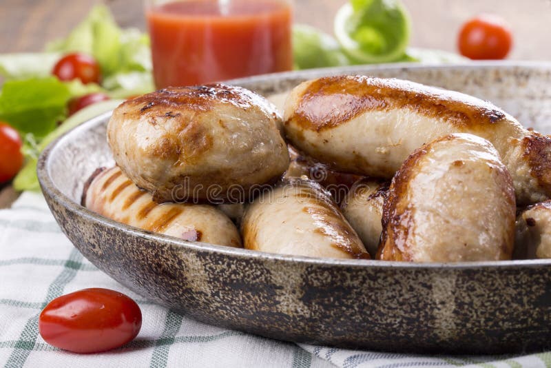 Gegrillte Hühnerwürste und -burger stockfotografie Gegrillte Hühnerwürste und -burger stockfotografie