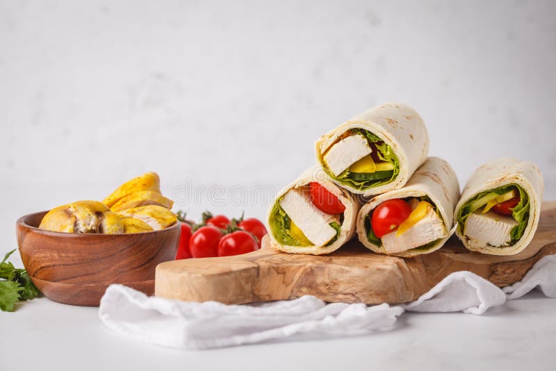 Gegrillte Tortillaverpackungen mit Huhn und Gemüse auf hölzernem BO lizenzfreie stockbilder Gegrillte Tortillaverpackungen mit Huhn und Gemüse auf hölzernem BO lizenzfreie stockbilder