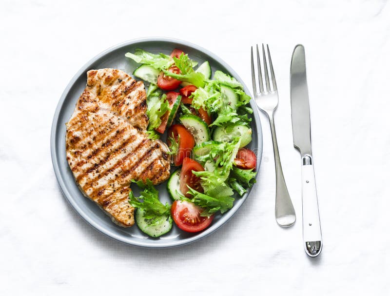 Gegrillte Truthahnhiebe und Gem? sesalat auf einem hellen Hintergrund, Draufsicht gesundes Lebensmitteldi? tkonzept stockfotografie