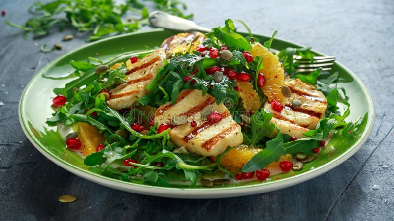 Gegrillter Halloumi-Käsesalat mit Orange, Raketenblättern, Granatapfel und Kürbiskern Gesunde Nahrung stockfotos Gegrillter Halloumi-Käsesalat mit Orange, Raketenblättern, Granatapfel und Kürbiskern Gesunde Nahrung stockfotos
