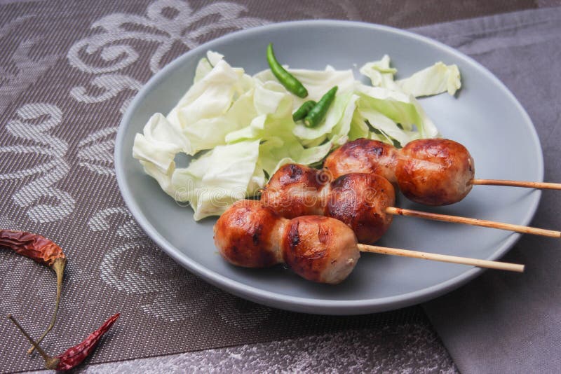 Gegrilltes fermentiertes Schweinefleisch und klebrige Reiswurst oder Wurst im nordöstlichen Stil, wie wir es nennen. Grillfermentiertes Schweinefleisch und klebrige Reiswurst oder Würstchen im nordöstlichen Stil, was wir sai krok als Straßenküche im Thailand 23102021 nennen