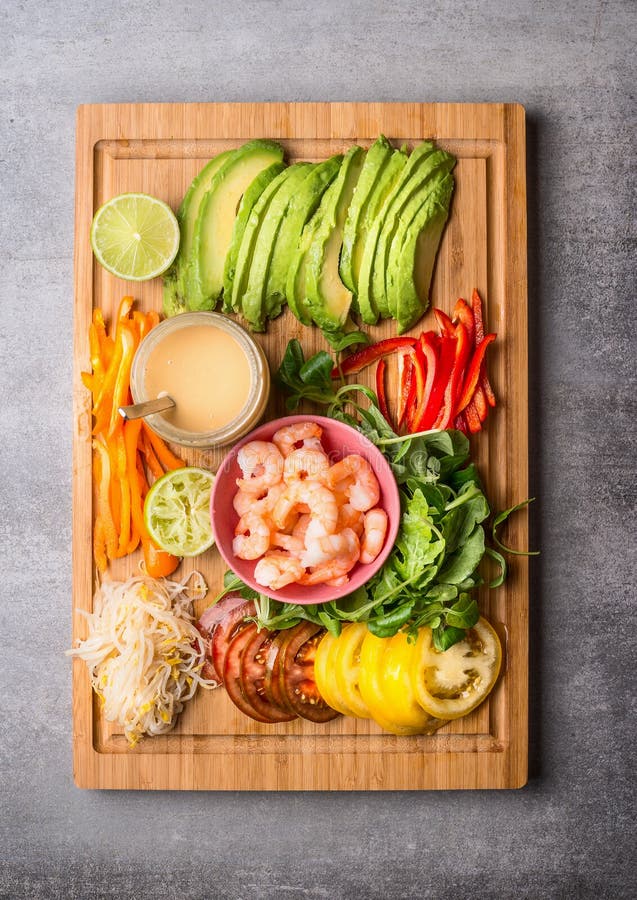 Gehacktes Gemüse: Avocado, Tomaten, Paprika, Kalk und Sprösslinge mit Garnele und Erdnuss tauchen auf hölzernes Schneidebrett ein lizenzfreie stockfotos